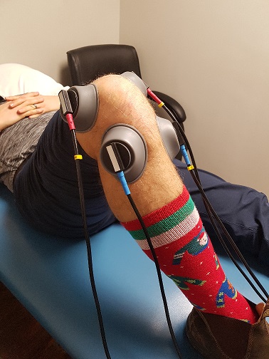 mans knee with suction cup ifc machine on to help with DOMS at the best oakville physiotherapy