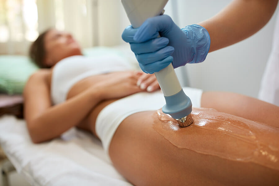 oakville shockwave treatment physiotherapist applying shockwave therapy to a females upper leg with ultrasound gel on her quad muscle