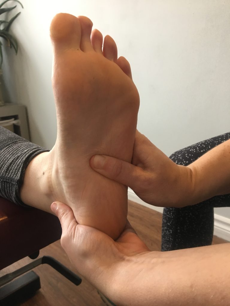 physiotherapy oakville plantar fasciitis treatment with the physio working on the arch of a patients foot
